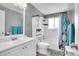 Well-lit bathroom with a vanity, toilet, shower, and patterned shower curtain at 8353 Adams Way, Denver, CO 80221