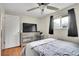 Cozy bedroom features a ceiling fan, hardwood floors, and a view out the window at 8353 Adams Way, Denver, CO 80221