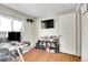 Functional bedroom featuring hardwood floors, neutral walls, and mounted TV at 8353 Adams Way, Denver, CO 80221