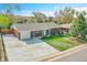 Charming brick home featuring a well-maintained lawn and long driveway with attached garage at 8353 Adams Way, Denver, CO 80221