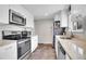 Modern kitchen with stainless steel appliances, white cabinets, and granite countertops at 8353 Adams Way, Denver, CO 80221