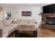 Inviting living room showcasing a large sectional sofa, wooden coffee table, and stone fireplace at 3812 W 24Th Ave, Denver, CO 80211