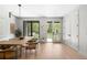 Dining room featuring light wood floors, a simple wooden table, and multiple doors to outdoor spaces at 417 N Madison St, Denver, CO 80206