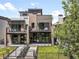 Modern home showcasing multiple balconies, sleek black railings, and a well-maintained front lawn at 417 N Madison St, Denver, CO 80206