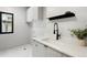 Clean laundry room features white cabinets, a modern faucet, a sleek countertop, and natural light at 417 N Madison St, Denver, CO 80206