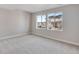 Bedroom with neutral carpet and light grey walls featuring a large window with a view at 6863 Oak Canyon Cir, Castle Pines, CO 80108