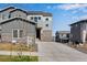 Modern two-story home featuring gray siding, stone accents, and a spacious driveway at 6863 Oak Canyon Cir, Castle Pines, CO 80108