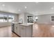 Bright, open-concept living area with an island, sliding doors, and wood flooring at 6863 Oak Canyon Cir, Castle Pines, CO 80108