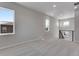 Spacious carpeted room with multiple windows and a staircase with metal railing at 6863 Oak Canyon Cir, Castle Pines, CO 80108