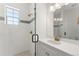 Bathroom with a glass shower, white tiling, mosaic accents, and vanity with gold hardware and white countertops at 15 Latigo Pl, Littleton, CO 80123