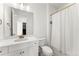 Well-lit bathroom featuring a white vanity with gold fixtures and a shower with a white curtain at 15 Latigo Pl, Littleton, CO 80123