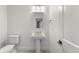 Bathroom with a pedestal sink, toilet, and modern fixtures at 15 Latigo Pl, Littleton, CO 80123