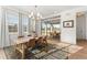Light-filled dining room with views of the yard has modern chandelier, wood table, and floor-to-ceiling windows at 15 Latigo Pl, Littleton, CO 80123