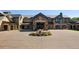 Luxury home exterior featuring stone accents, fountain, circular driveway and manicured landscaping at 15 Latigo Pl, Littleton, CO 80123