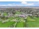 Scenic aerial view of golf course and clubhouse with mountain backdrop at 15 Latigo Pl, Littleton, CO 80123