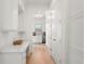 Hallway features white cabinets with marble countertops, gold hardware and views of the kitchen at 15 Latigo Pl, Littleton, CO 80123