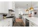 Gourmet kitchen features stainless appliances, white cabinets with gold hardware, and marble backsplash at 15 Latigo Pl, Littleton, CO 80123
