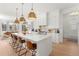 Modern kitchen with white cabinets, marble countertops, stainless steel appliances, and pendant lighting at 15 Latigo Pl, Littleton, CO 80123