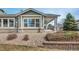 Back exterior view with low-maintenance landscaping and shaded patio space at 15123 Xenia St, Thornton, CO 80602