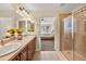 Elegant bathroom featuring double sinks, tiled shower, and access to the Primary bedroom at 15123 Xenia St, Thornton, CO 80602