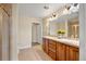 Well-lit bathroom with double vanity, tiled floors, and glass-enclosed shower at 15123 Xenia St, Thornton, CO 80602
