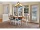 A dining room with a chandelier, carpet, and a door to the exterior, under a bright blue sky at 15123 Xenia St, Thornton, CO 80602