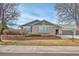 A single story home with a green garage door, beige brick, and a landscaped yard on a bright day at 15123 Xenia St, Thornton, CO 80602