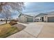 A single story home with a green garage door, beige brick, and a concrete drive under a partly cloudy sky at 15123 Xenia St, Thornton, CO 80602