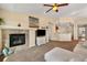 A cozy living room with a carpet, fireplace, and a seamless flow into the kitchen, all under a vaulted ceiling at 15123 Xenia St, Thornton, CO 80602