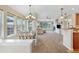 A light and airy living room and dining room with many windows, a fireplace, and a ceiling fan at 15123 Xenia St, Thornton, CO 80602
