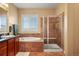 Bathroom features a soaking tub, tiled shower with glass door, and single window at 11023 Glengate Cir, Highlands Ranch, CO 80130