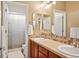 Bathroom with double sinks, wood cabinets, and a shower with striped curtain at 11023 Glengate Cir, Highlands Ranch, CO 80130