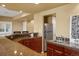 Basement kitchenette with stainless steel refrigerator, dark wood cabinets, and granite countertops at 11023 Glengate Cir, Highlands Ranch, CO 80130