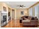 Comfortable living room features a stone fireplace, hardwood floors, and a ceiling fan at 11023 Glengate Cir, Highlands Ranch, CO 80130