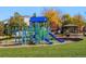 Bright and inviting playground with colorful blue and green play structures on a lush green lawn at 11023 Glengate Cir, Highlands Ranch, CO 80130