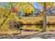 Scenic view of a pond reflecting the surrounding trees and foliage, complemented by a park bench at 11023 Glengate Cir, Highlands Ranch, CO 80130