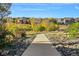 Concrete walking path through the community's natural space featuring lush foliage and trees in autumnal colors at 11023 Glengate Cir, Highlands Ranch, CO 80130