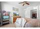 Bright bedroom featuring ceiling fan, dresser with TV, and a large closet for storage at 4604 Copeland Cir # 101, Highlands Ranch, CO 80126