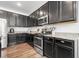 Well-lit kitchen features dark cabinetry, stainless steel appliances, and stone countertops at 4604 Copeland Cir # 101, Highlands Ranch, CO 80126