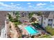 Aerial view of community pool and apartments with manicured landscaping under a sunny sky at 15700 E Jamison Dr # 8-208, Englewood, CO 80112