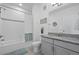 Well-lit bathroom with shower-tub combo, gray vanity, granite countertop, and decorative accents at 15700 E Jamison Dr # 8-208, Englewood, CO 80112