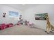 Bright bedroom featuring neutral carpet, window and play area with Minnie Mouse decor at 15700 E Jamison Dr # 8-208, Englewood, CO 80112