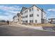 Attractive multi-story building with gray and white exterior, landscaped grounds, and ample parking at 15700 E Jamison Dr # 8-208, Englewood, CO 80112