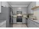 Modern kitchen with stainless steel appliances and stylish gray cabinetry at 15700 E Jamison Dr # 8-208, Englewood, CO 80112