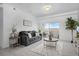 Bright living room with a gray sofa, decorative rug, and sliding glass doors to a balcony at 15700 E Jamison Dr # 8-208, Englewood, CO 80112