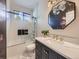 Stylish bathroom with modern vanity, decorative mirror, and glass-enclosed shower/tub at 1020 S Ammons Cir, Lakewood, CO 80226