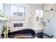 Bright bathroom features a luxurious soaking tub, marble tiling, and a glass-enclosed shower with bench at 1020 S Ammons Cir, Lakewood, CO 80226