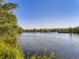 Scenic view of a serene lake surrounded by lush greenery under a clear blue sky at 1020 S Ammons Cir, Lakewood, CO 80226