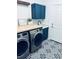 Well-designed laundry room featuring trendy patterned tile flooring, butcher block folding counter, and modern cabinetry at 1020 S Ammons Cir, Lakewood, CO 80226