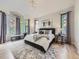 Spacious main bedroom with large windows, a decorative chandelier, and ample natural light at 1020 S Ammons Cir, Lakewood, CO 80226